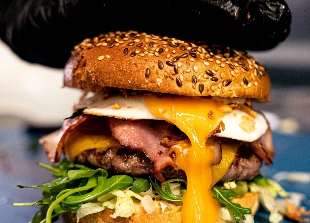 A freshly prepared burger with cheese, lettuce and a seeded bun, from GFV’s original website